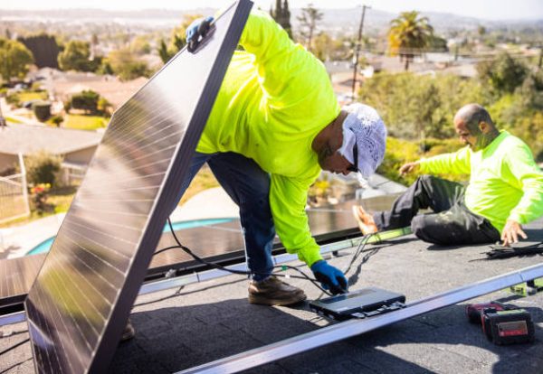 A team of workers installing solar panels on a home in Southern California