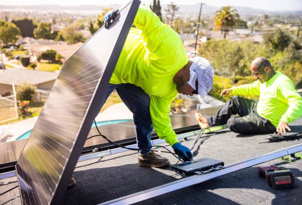 A team of workers installing solar panels on a home in Southern California