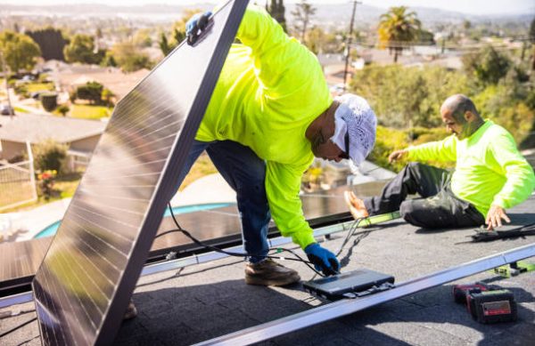 A team of workers installing solar panels on a home in Southern California